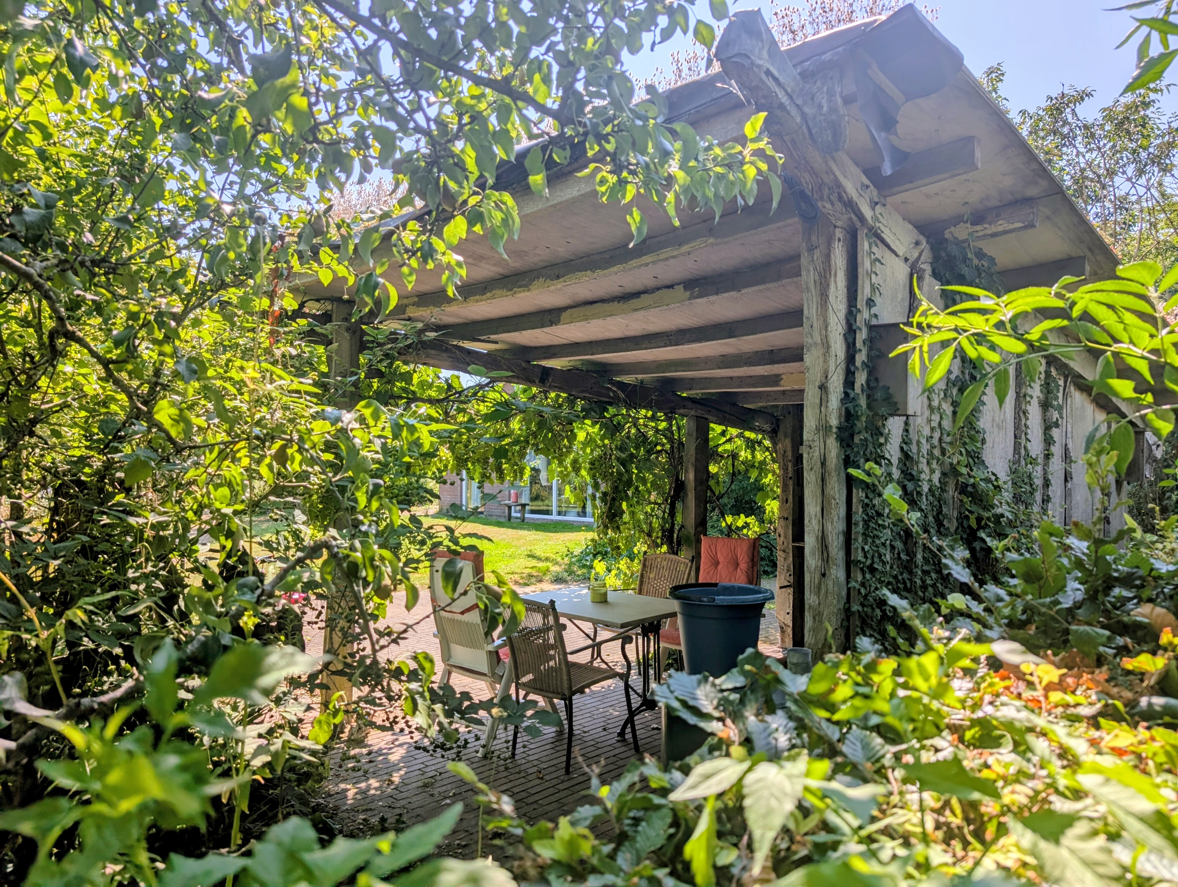 Overdekt terras en rustige zitplek in de tuin